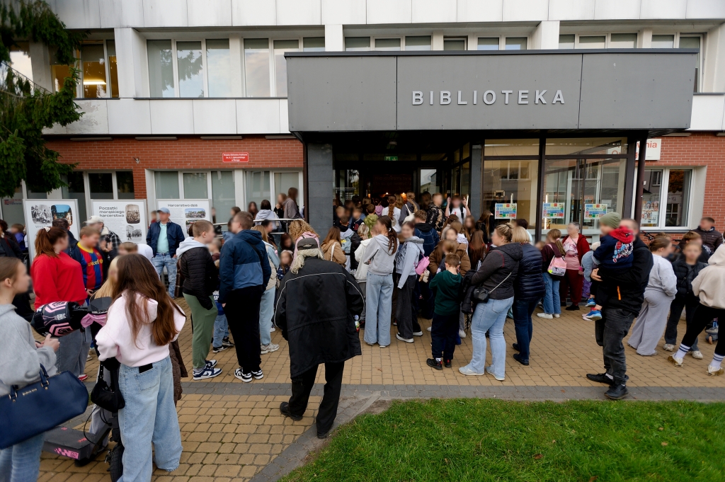 Tłum uczestników przed wejściem do Miejskiej Biblioteki Publicznej w Morągu.