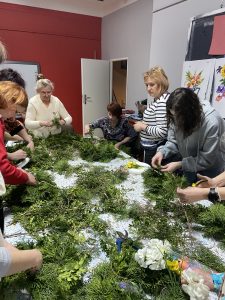 Grupa kobiet robiących wianki wielkanocne.