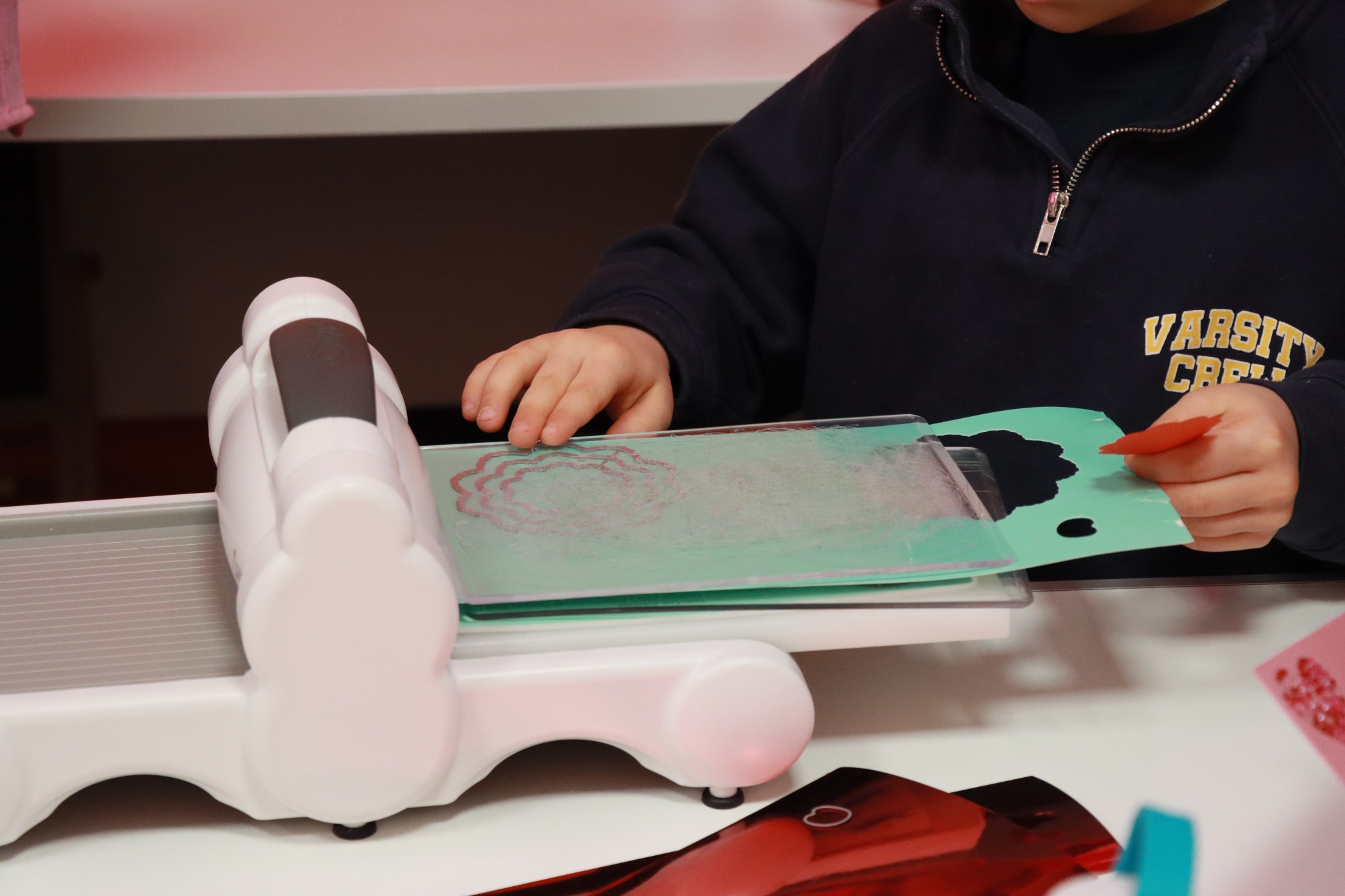 ręce dzieci które używają maszynki do scrapbookingu