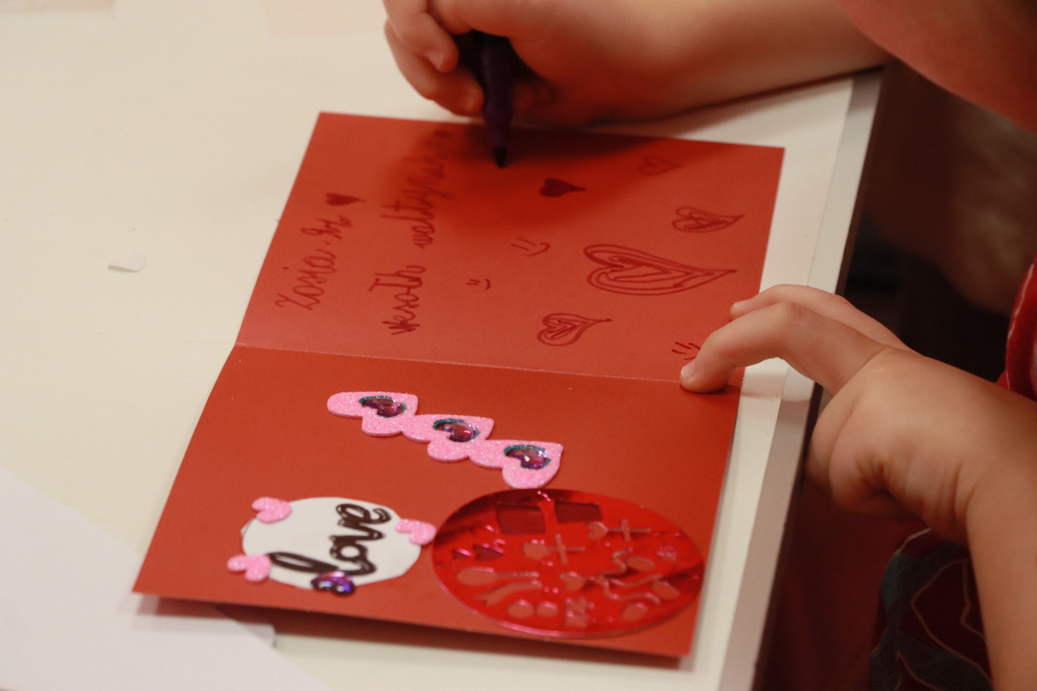 dziecko wykańczające kartkę walentynkową