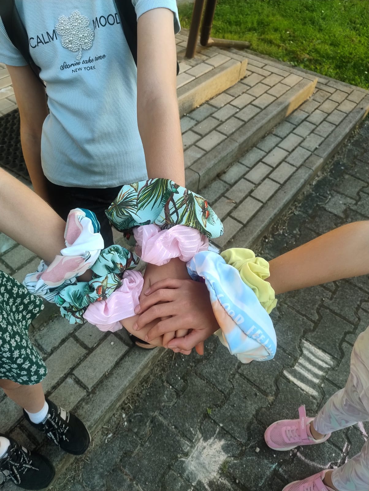 ręce trzech dziewczynek z wieloma scrunchies w różne wzory