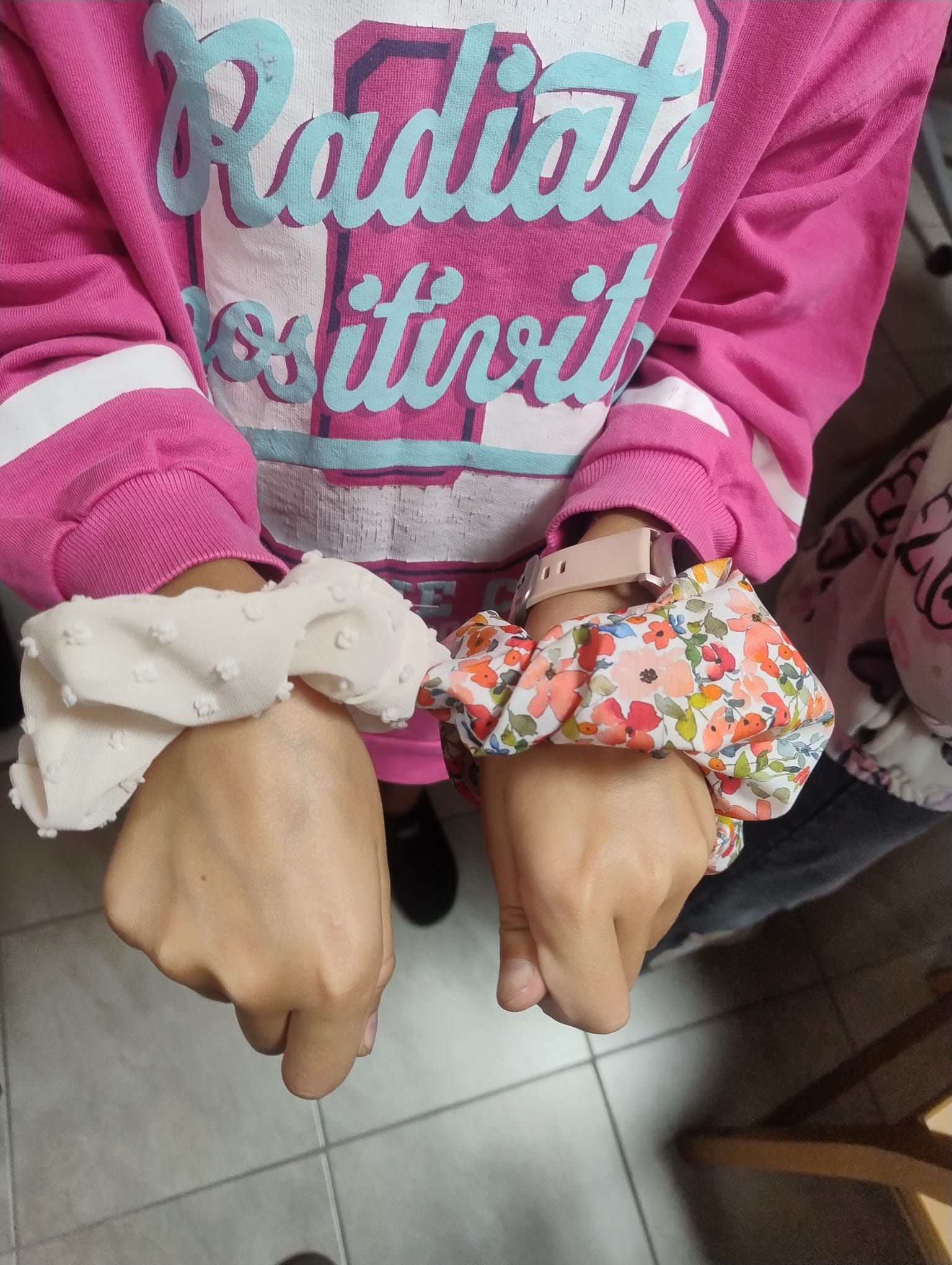 zdjęcie rąk dziewczynki, a na nich gumki do włosów scrunchies