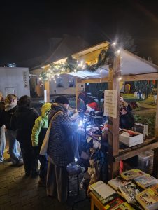 oświetlone stoisko Pracowni Orange, drewniana budka z dekoracjami świątecznymi