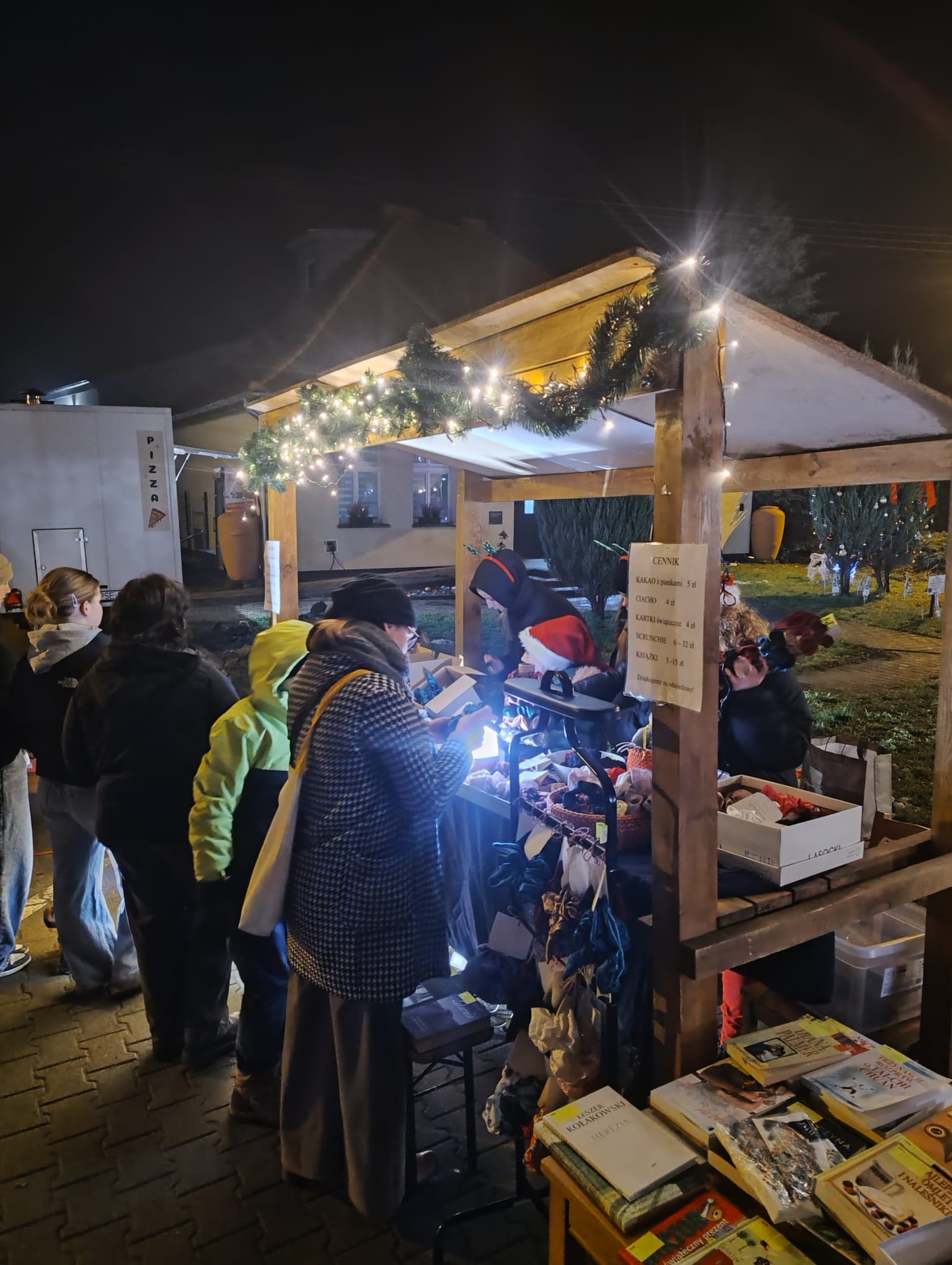 oświetlone stoisko Pracowni Orange, drewniana budka z dekoracjami świątecznymi