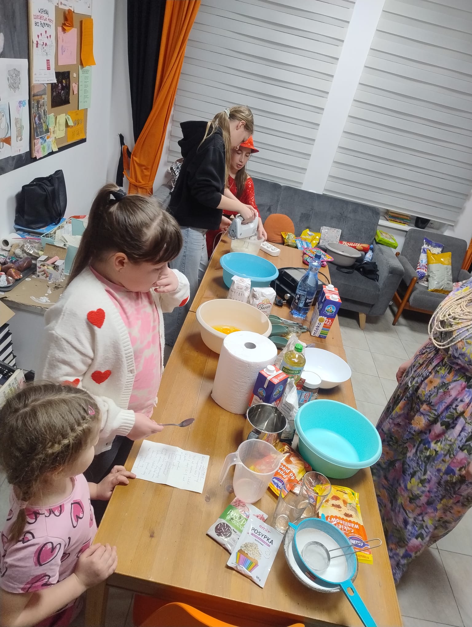 dzieci stojące przy stole przygotowujące się do robienia gofrów