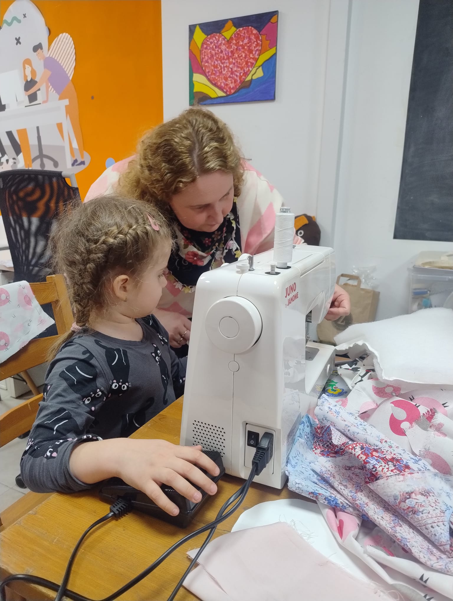 Dziewczynka ucząca się szyć na maszynie