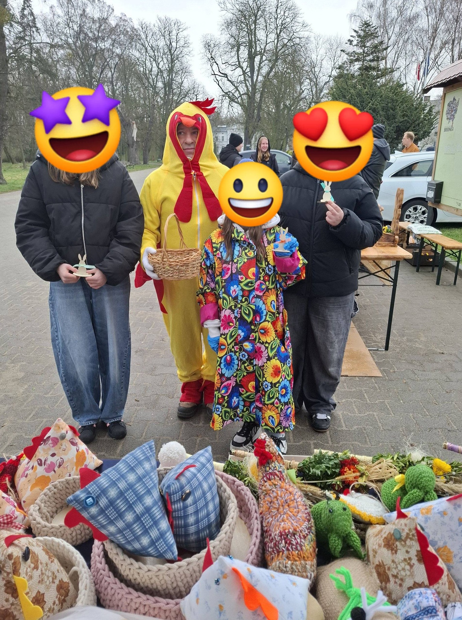 Mężczyzna przebrany za kurczaka pozujący z innymi osobami.