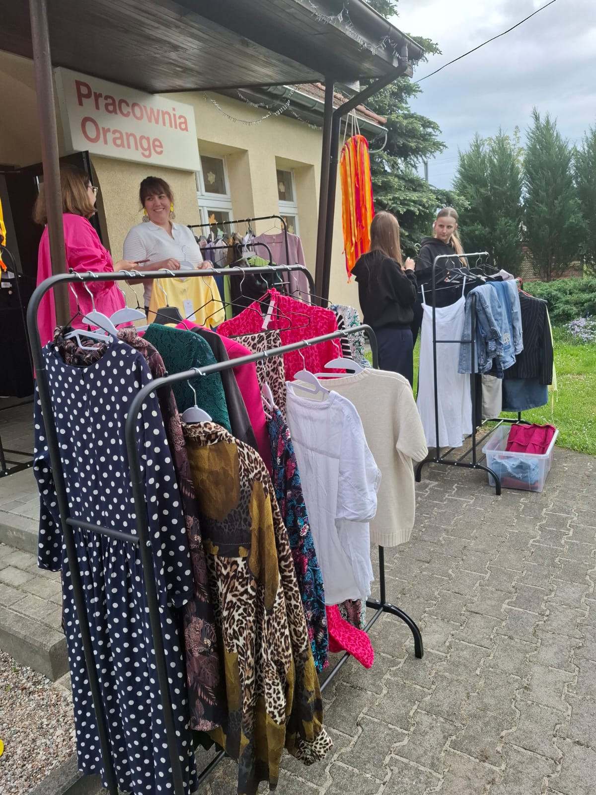 stojak i z ubraniami i widoczne osoby