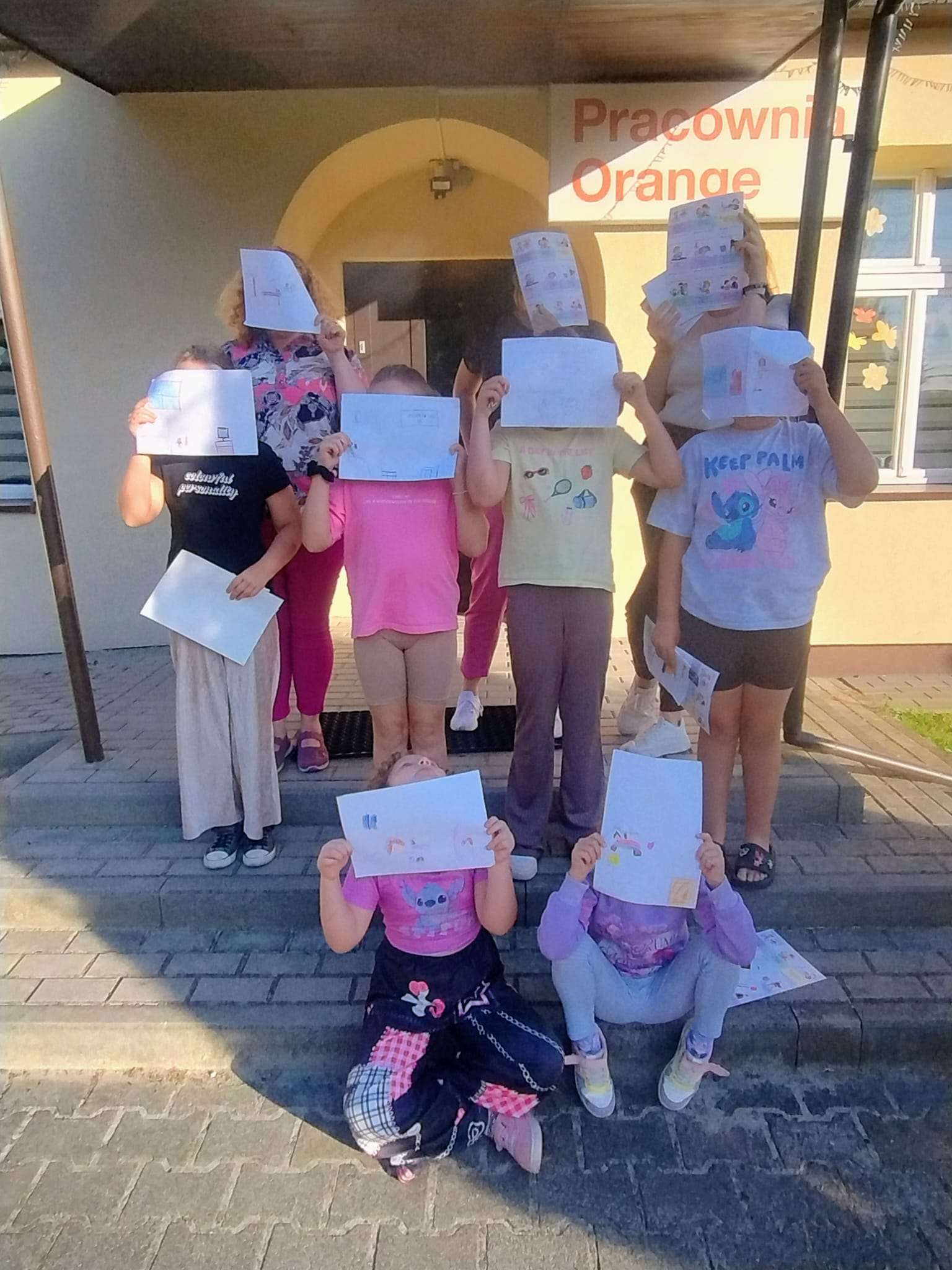 dzieci i dorośli stoją na schodach