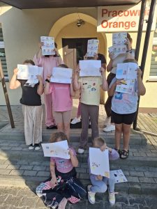 na zdjęciu są uczestnicy warsztatów, trzymająw ręku kartkę z naklejkami dotyczącymi higeiny cyfrowej