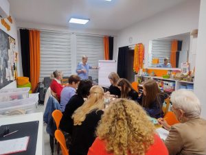Grupa osób siedzących w Pracowni Orange.