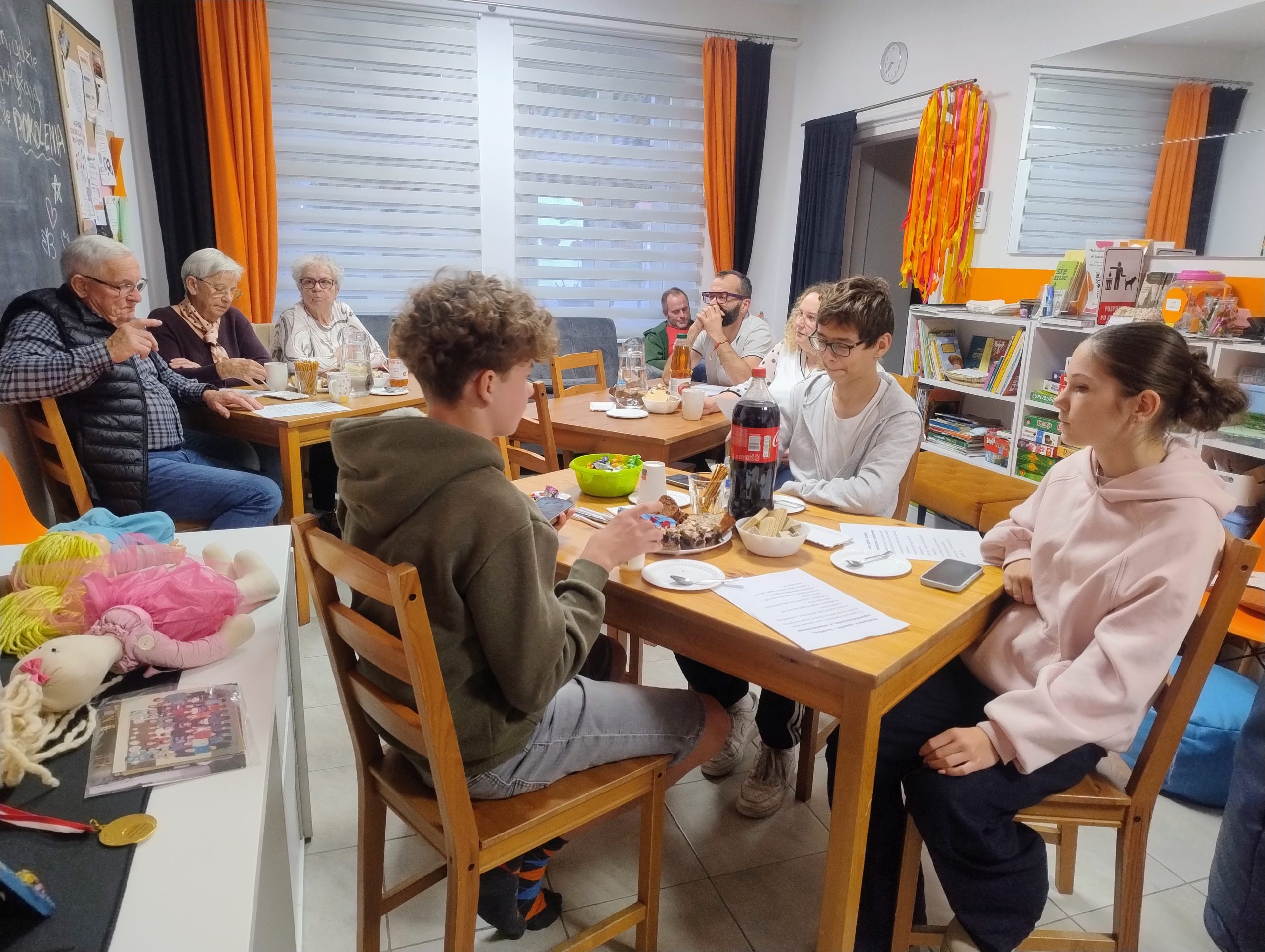 na zdjęciu widać ujęcie sali w pracowni orange i uczestnikó spotkania siędzących przy stole