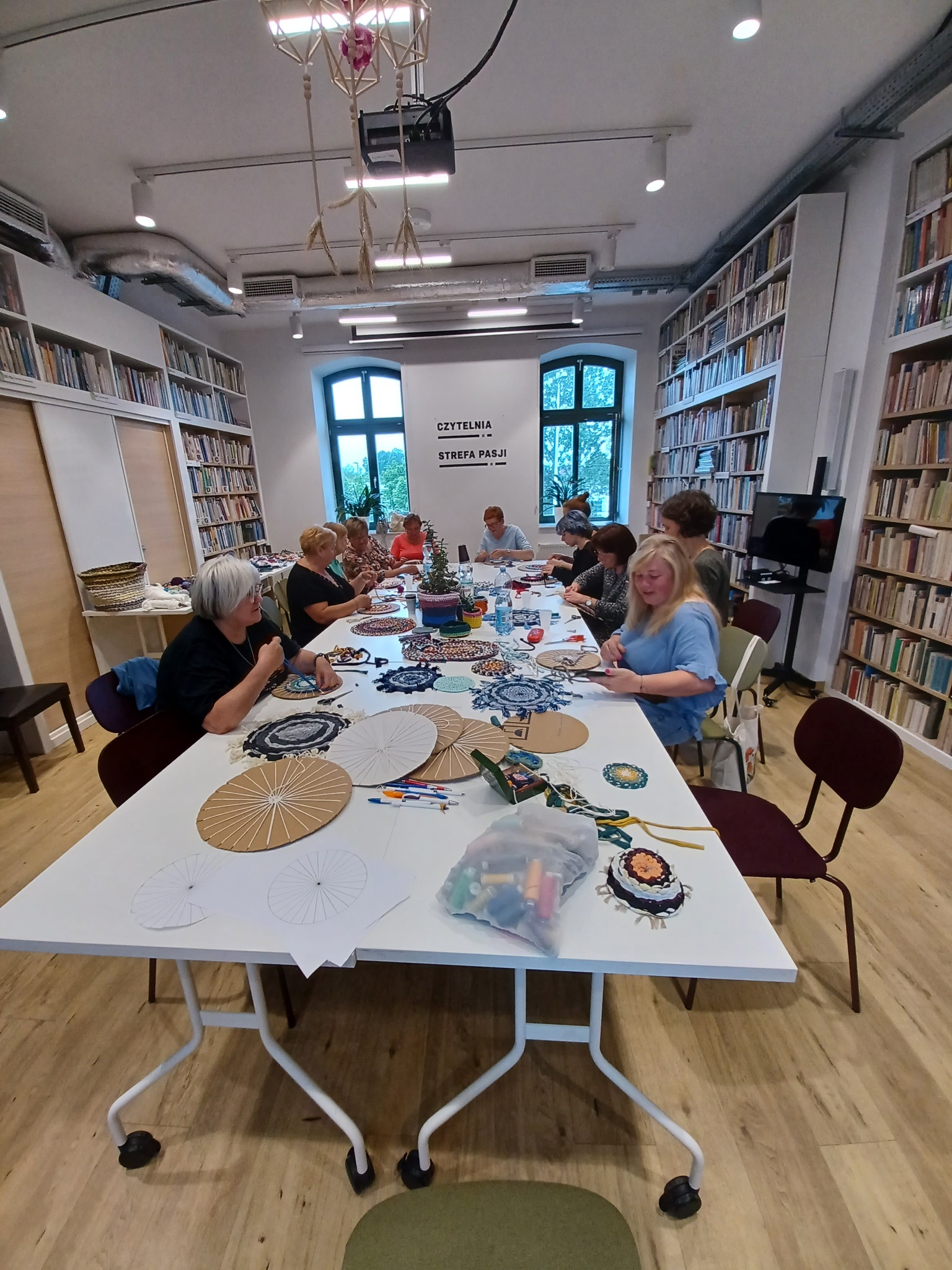 grupa warsztatowa przy stole wykonująca dekoracje handame