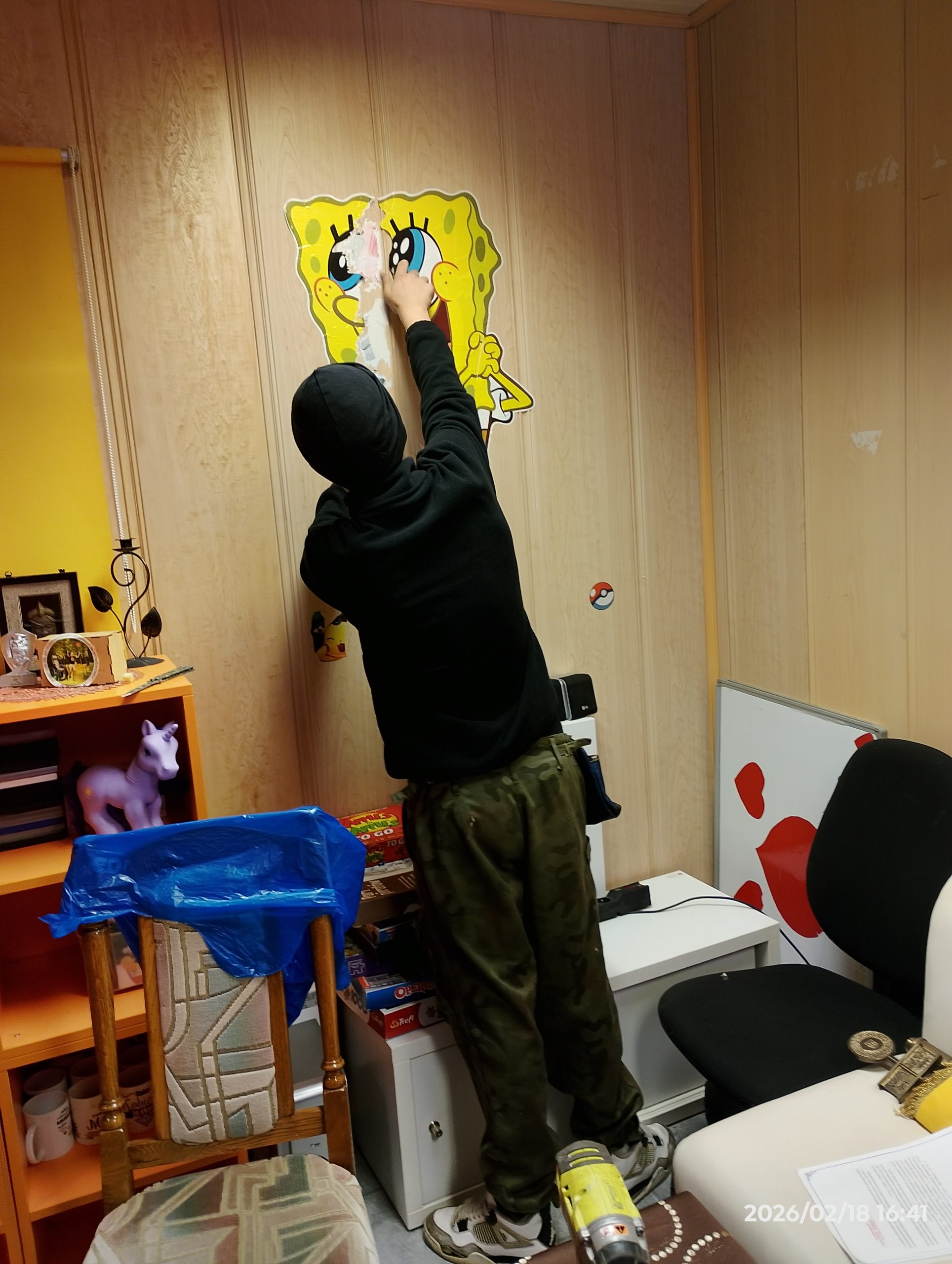 Osoba zdziera naklejkę ze ściany