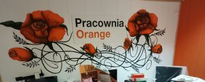 ściana z napisem Pracownia Orange i namalowanymi kwiatami