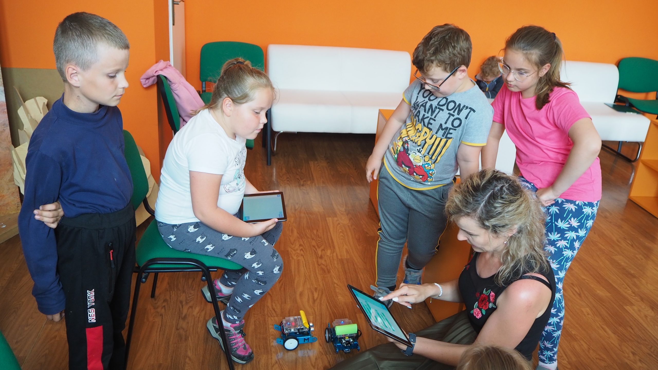 dzieci korzystają z tabletów podczas zajęć z kodowania