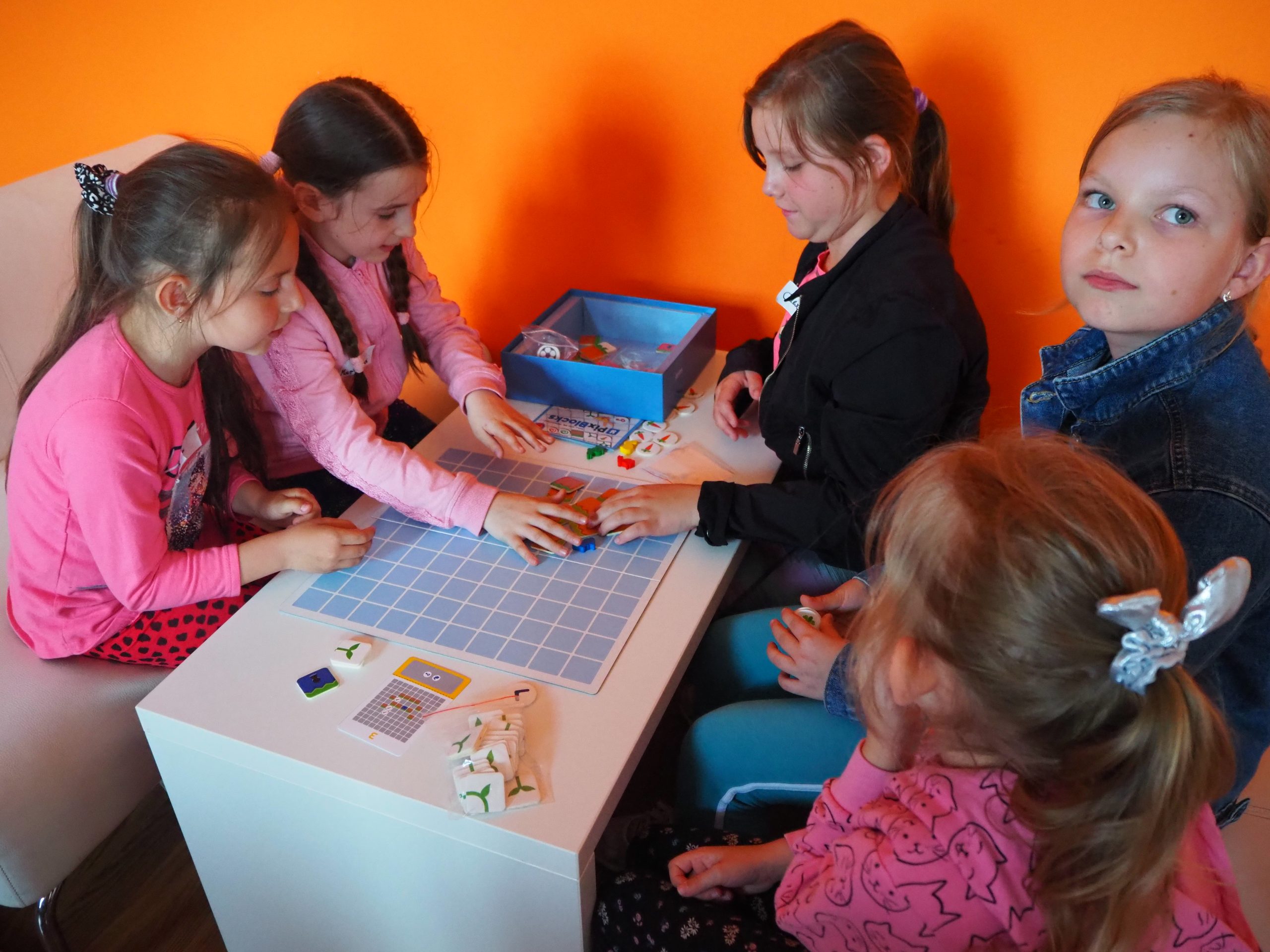 dziewczynki pryz stoliku grają w planszówki podczas zajęć z kodowania