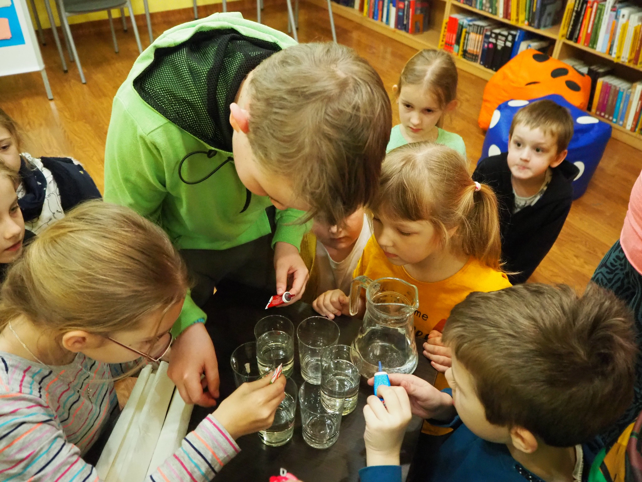 dzieci przy stoliku zabarwiają wodę barwnikami