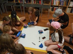 Grupa dzieci podczas programowania robotów.