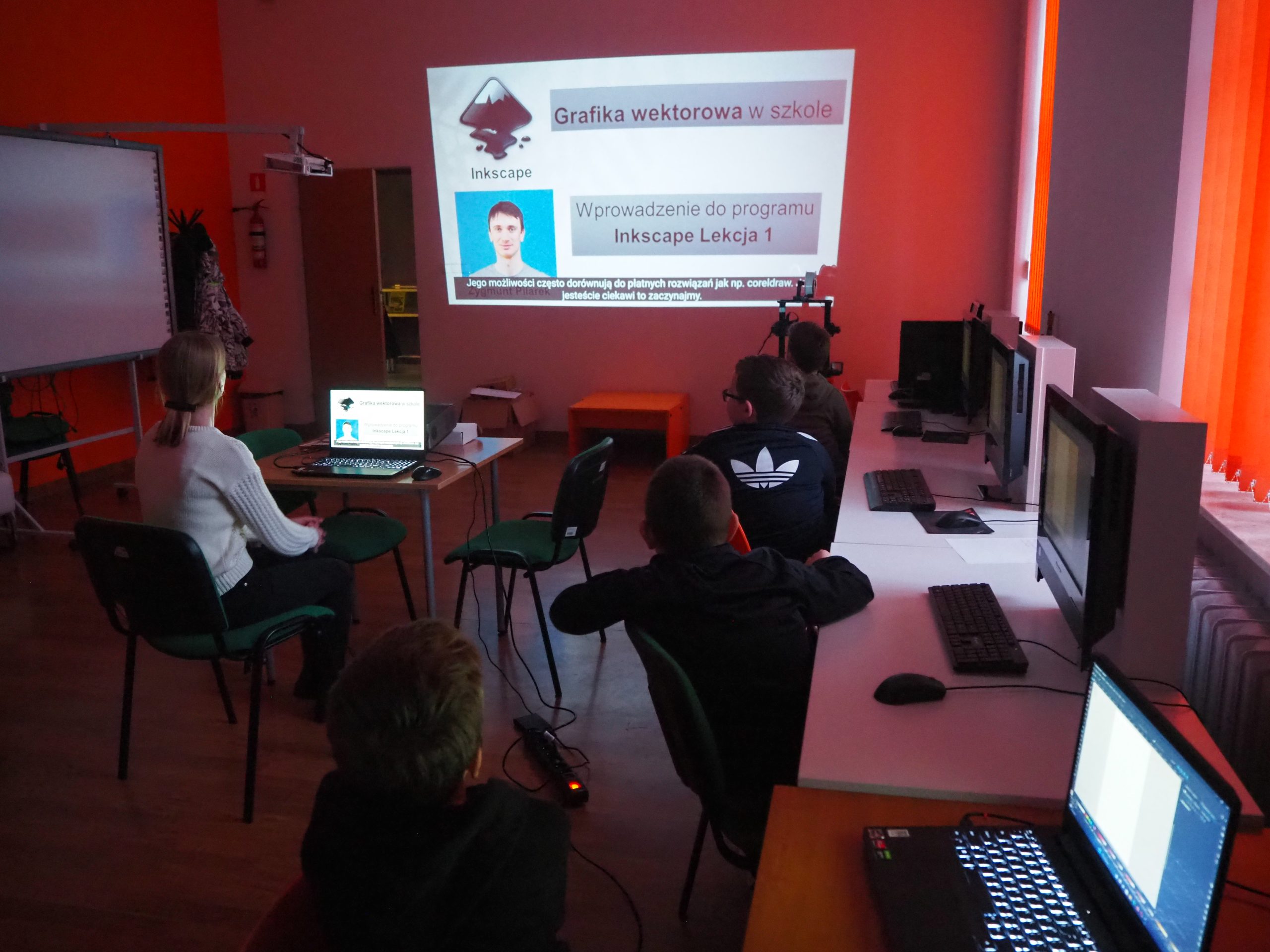Dzieci oglądają prezentację dotyczącą grafiki wektorowej.