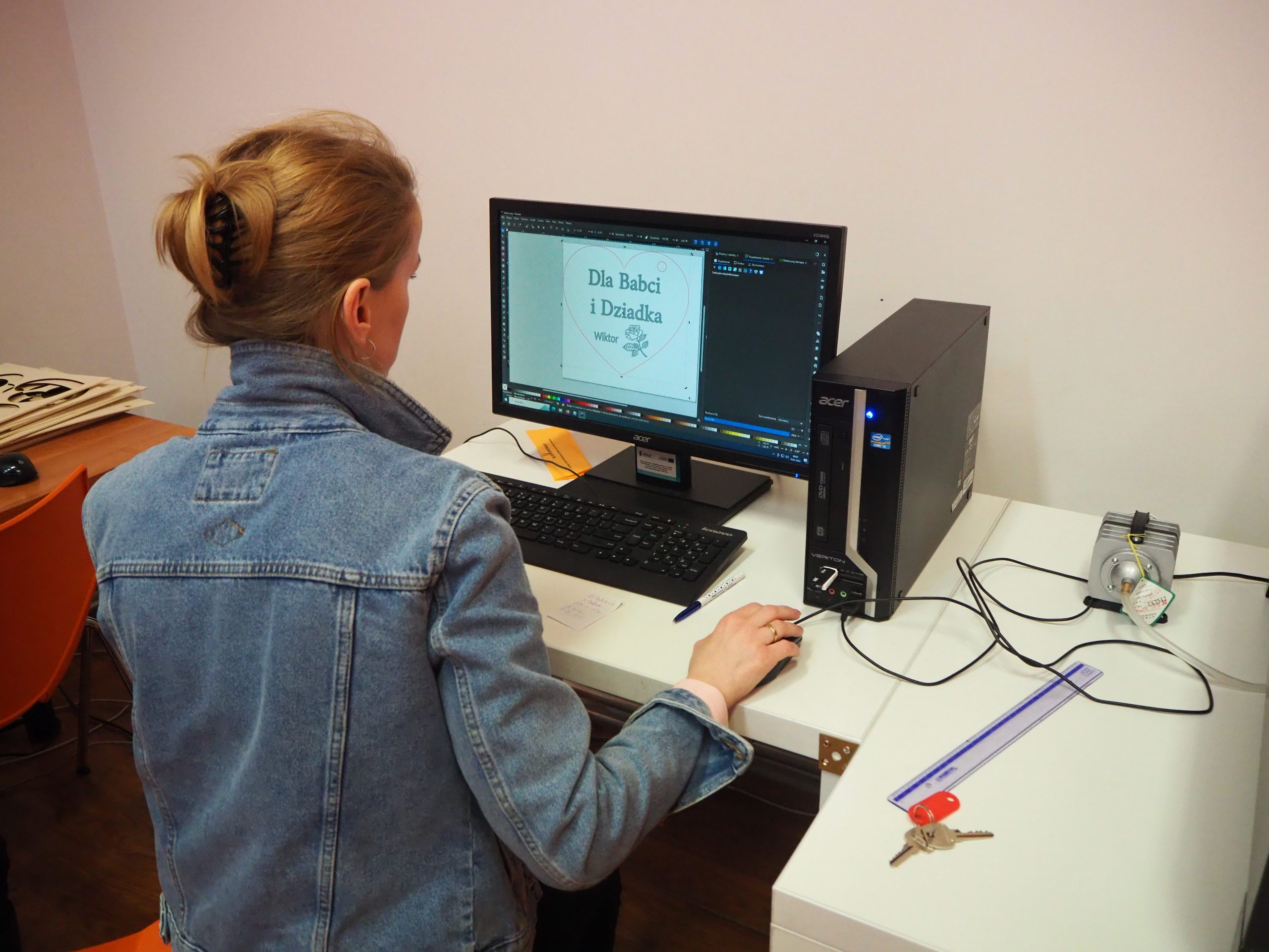 Prowadząca zajęcia projektuje na komputerze napis.