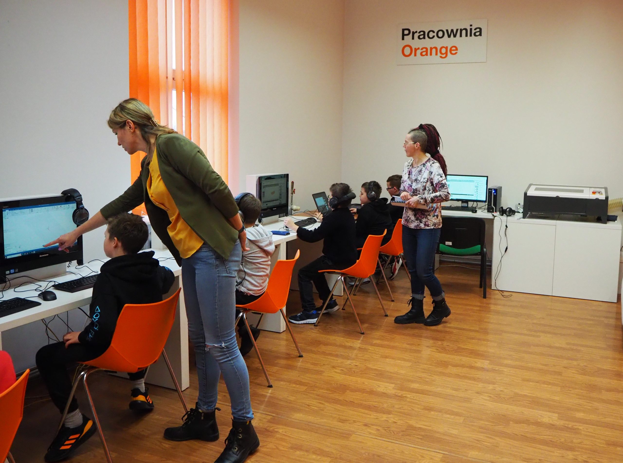 Uczestnicy warsztatów siedzą przed komputerami.