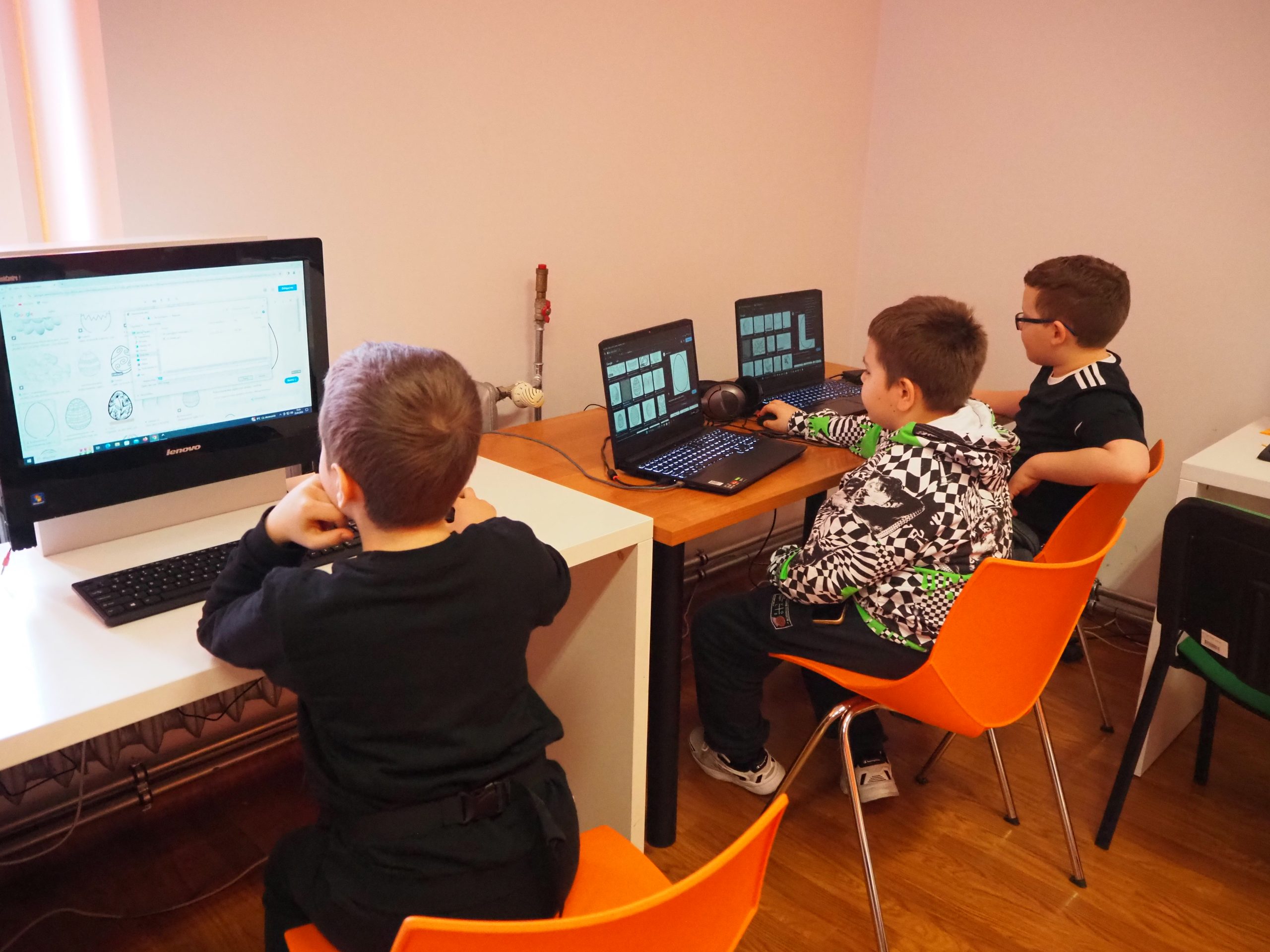 Chłopcy siedzący przy komputerach.