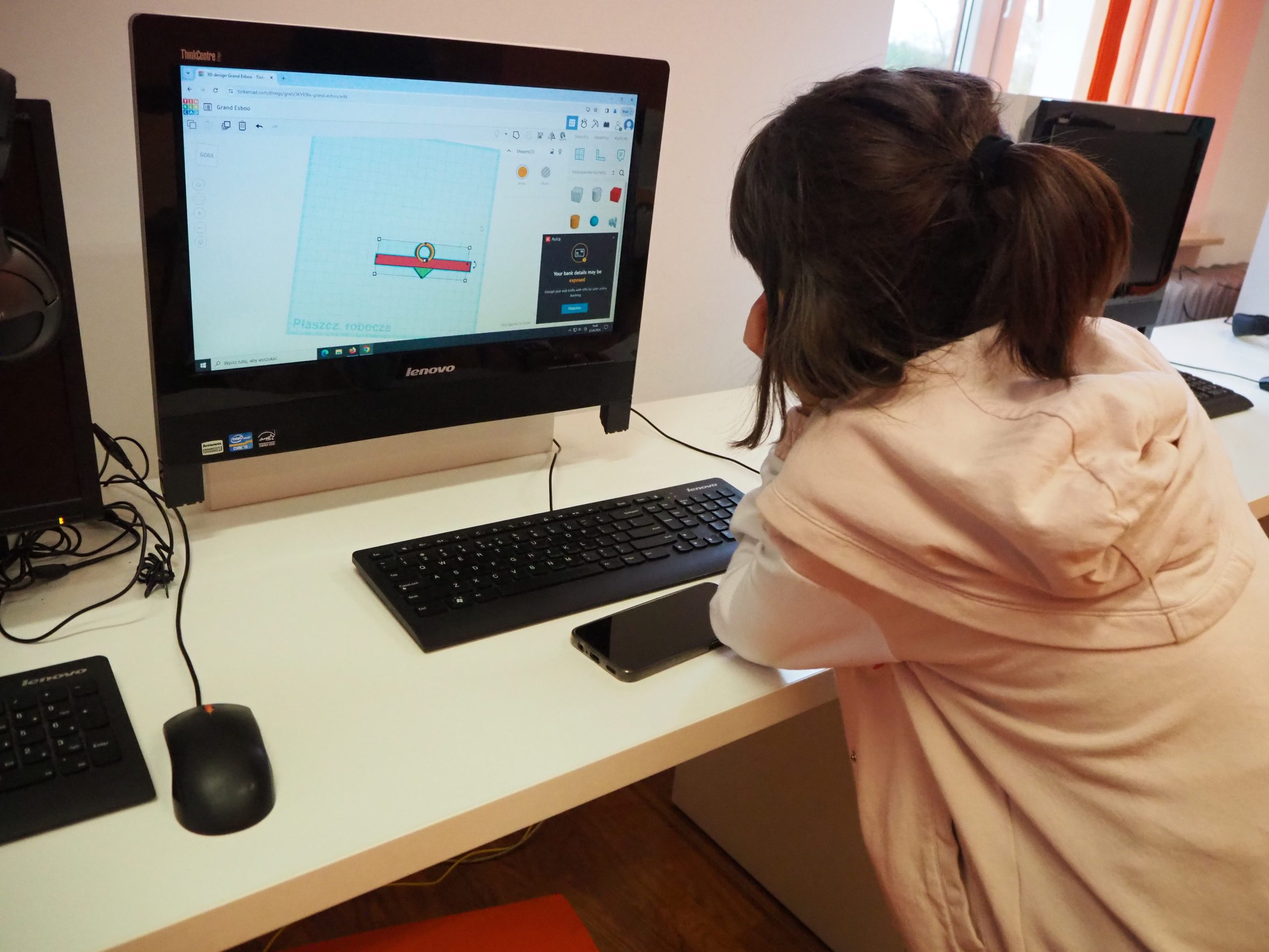 Dzieci siedzące przy komputerach.