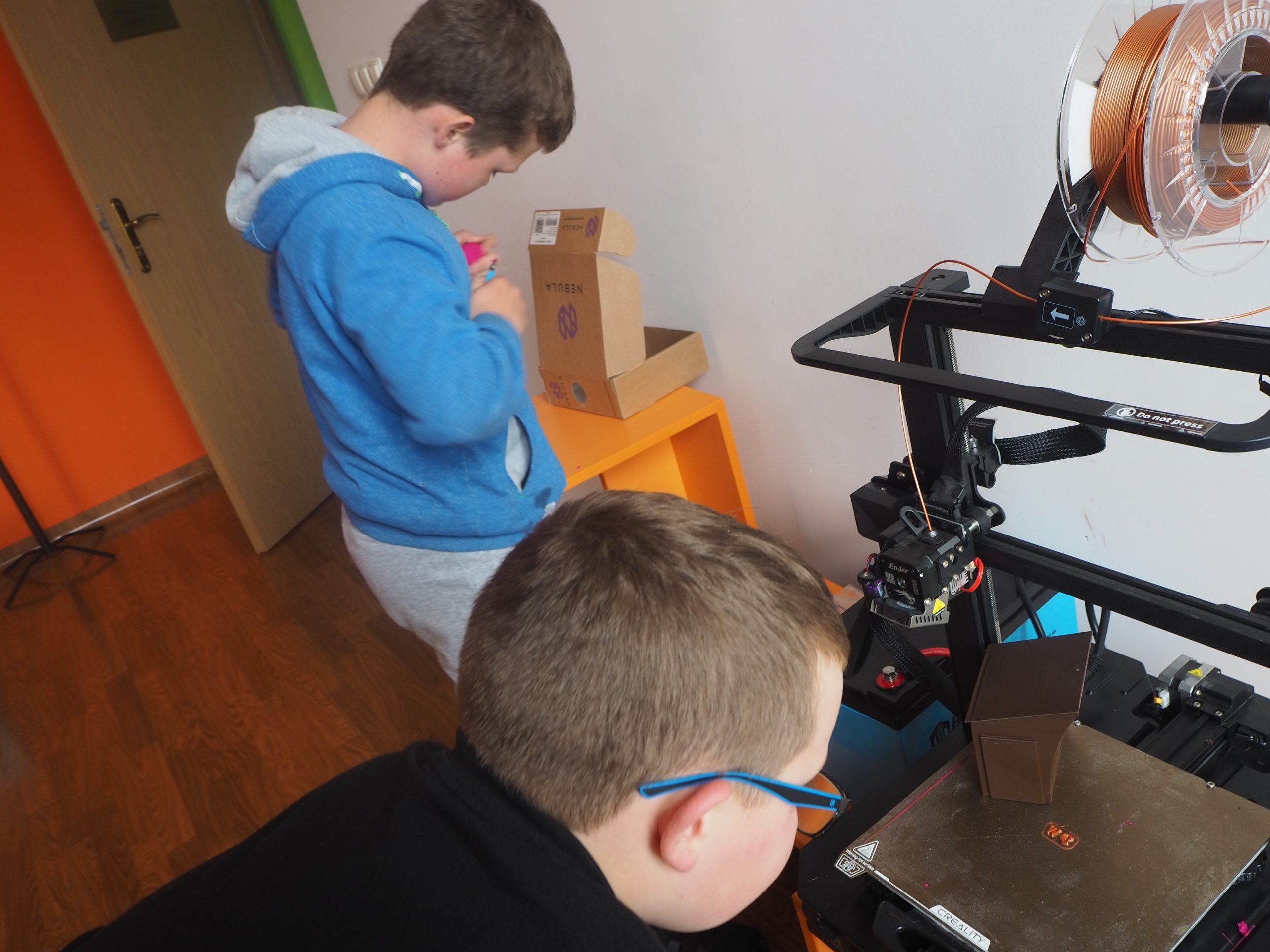 chłopiec patrzy jak drukarka 3 d drukuje