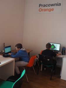 dwóch uczestników zajęć siedzi przed laptopem
