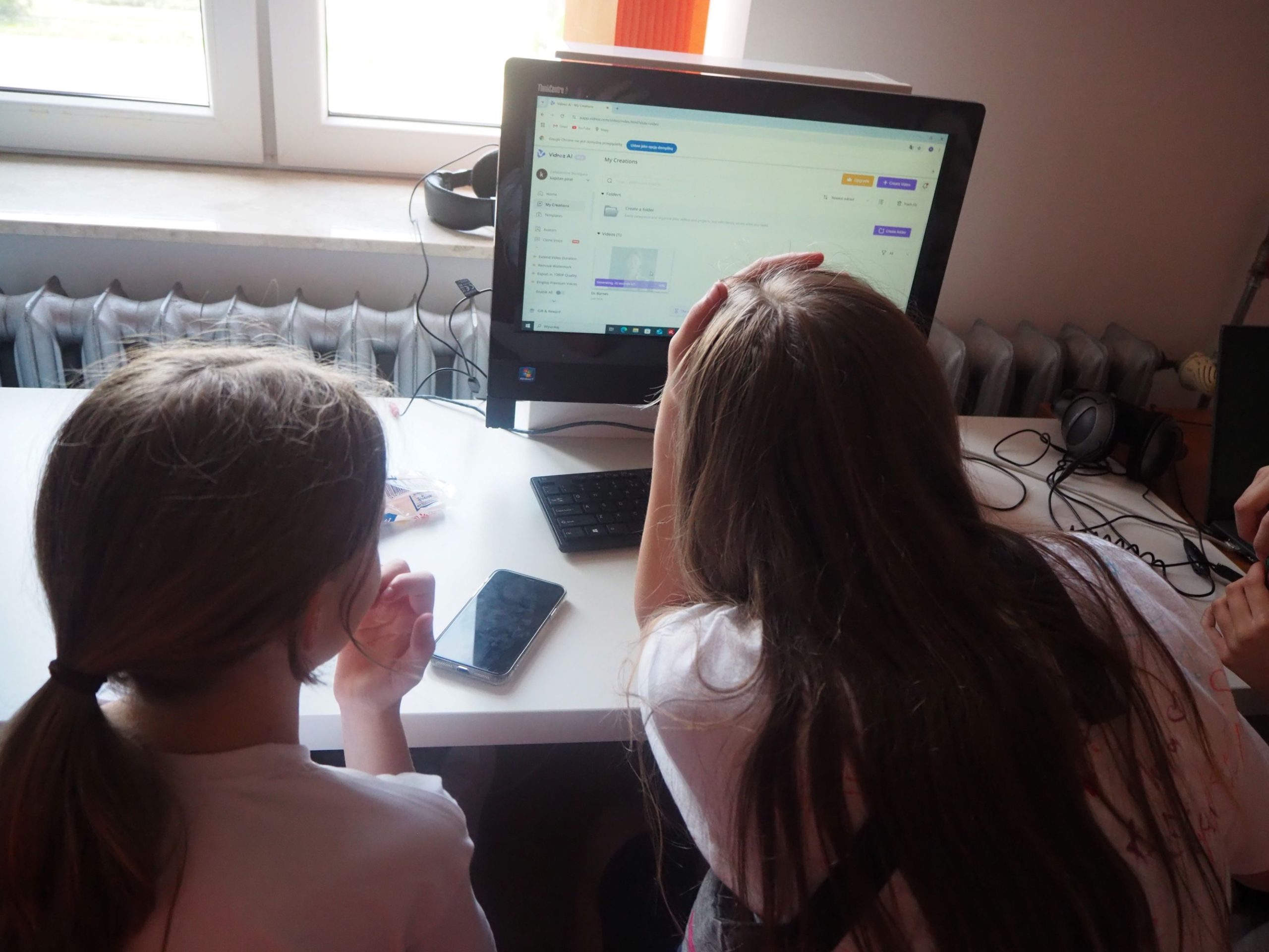 dwie dziewczynki siedzące przed monitorem