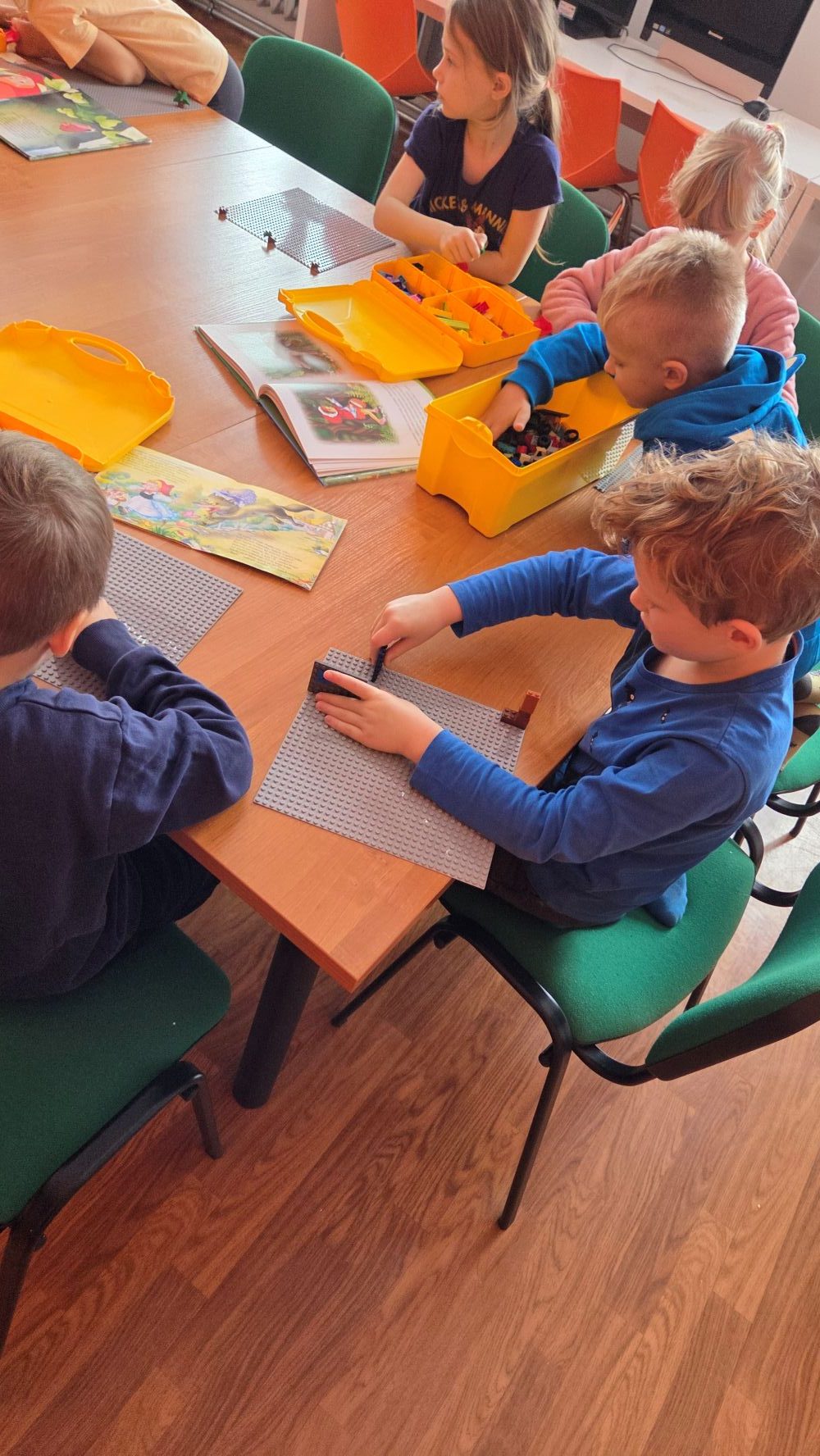 dzieci układają na podkładce klocki lego
