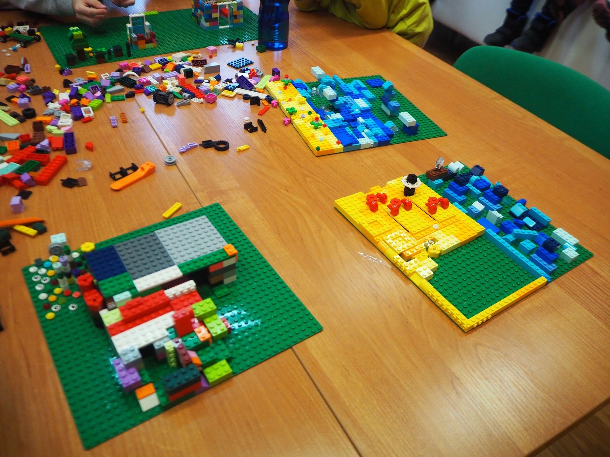 Na stole widać zimowe konstrukcje wybudowane przez dzieci z klocków lego