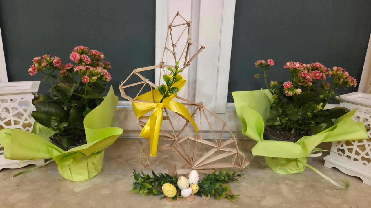 Zajączek wykonany z patyków z przywiązaną żółtą wstążką