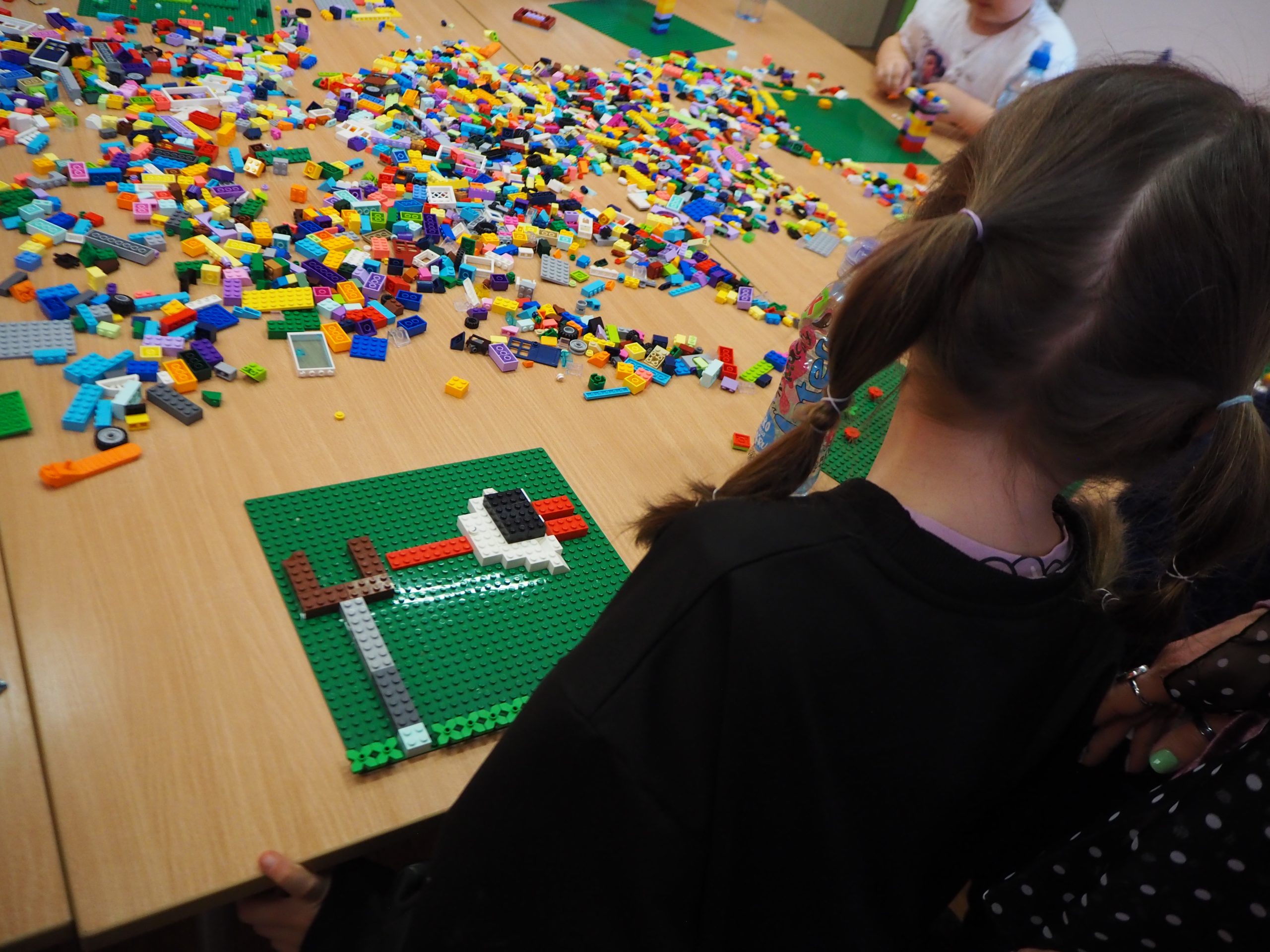 rozsypane na stole klocki lego i ułożony bocian