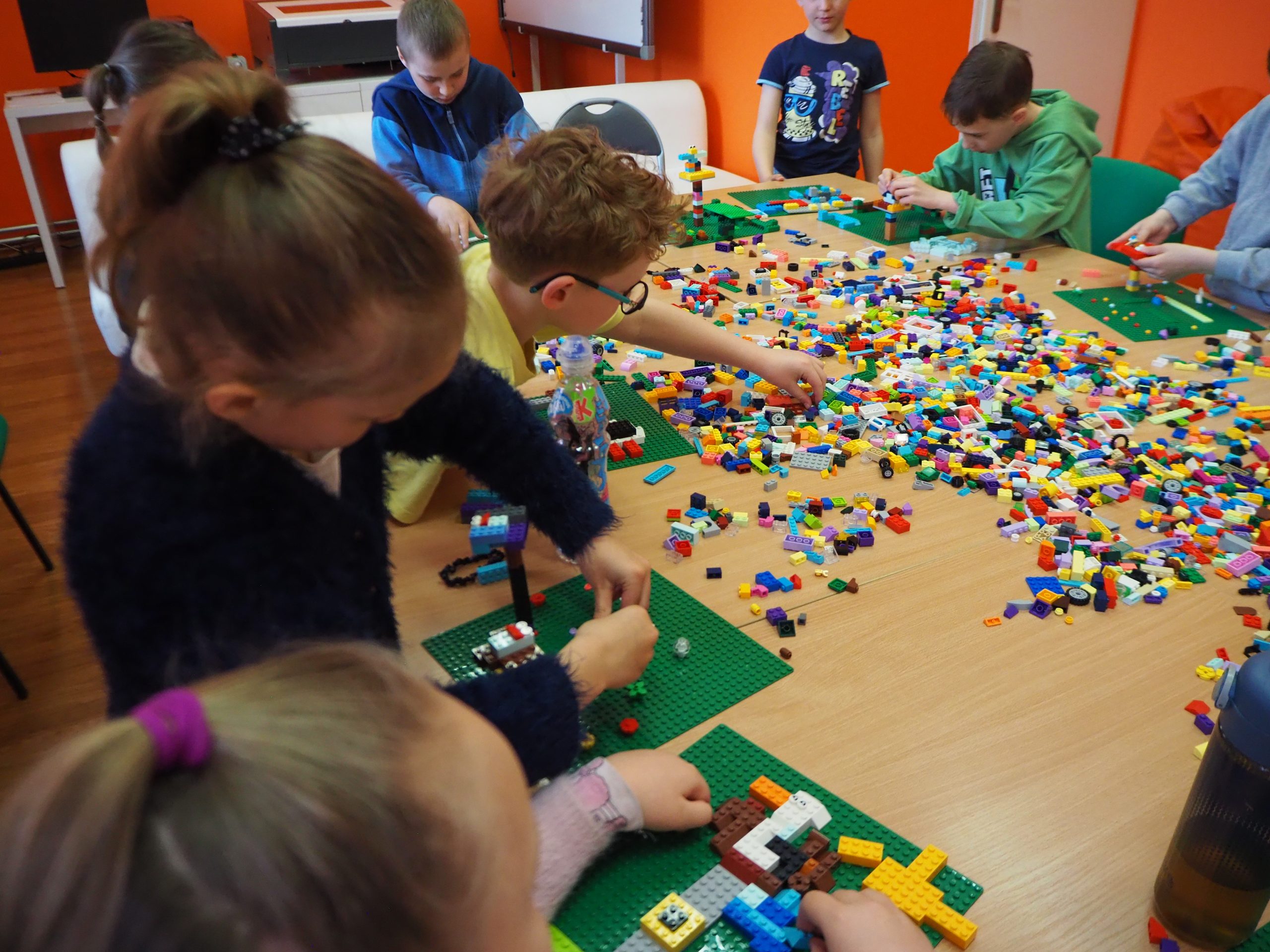dzieci układają bociany z klocków lego