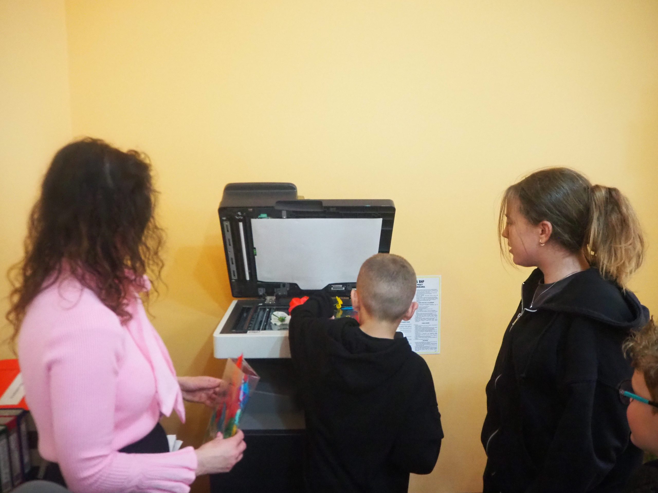 Dzieci stoją prz bibliotecznym skanerze