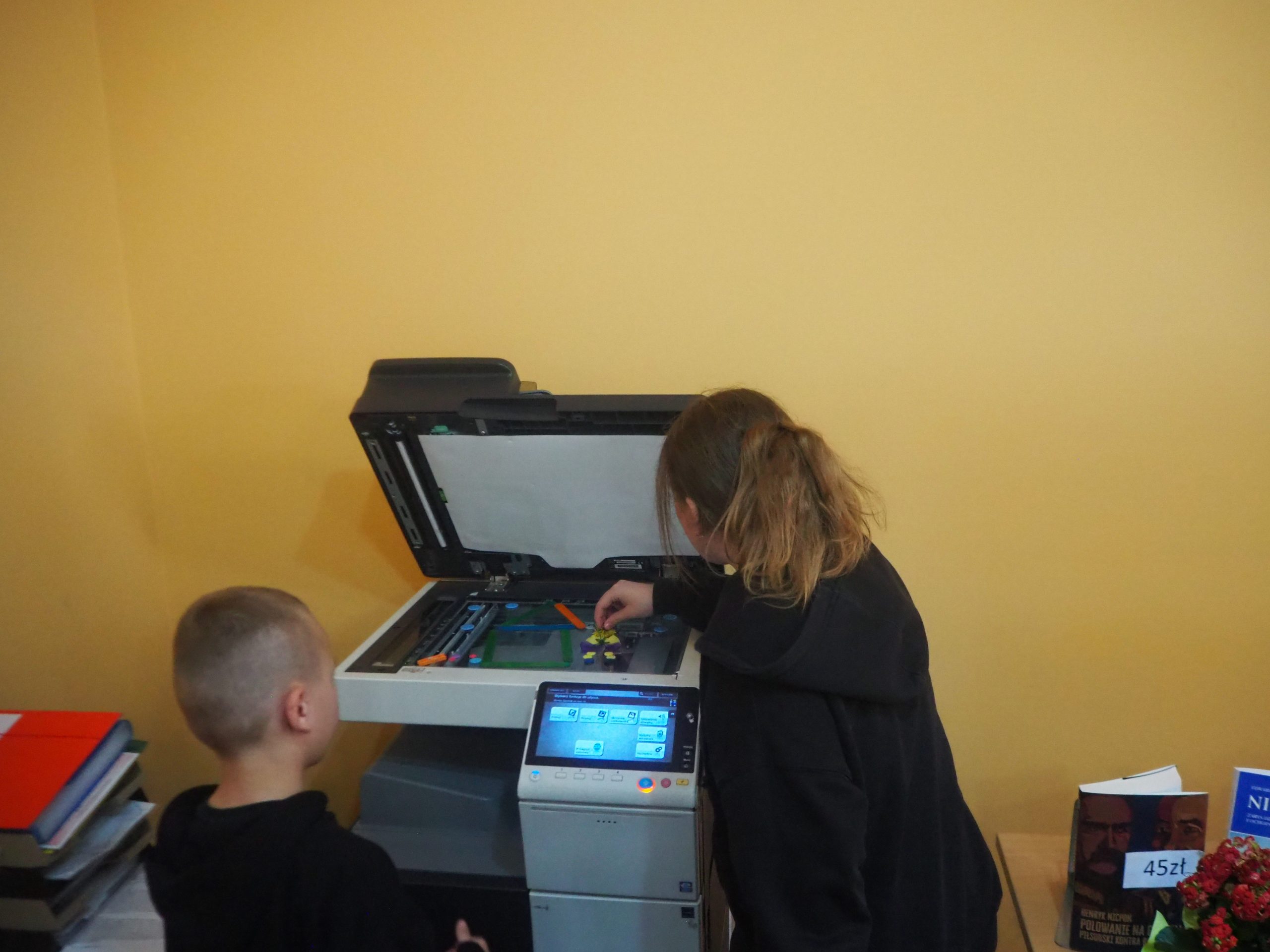 chłopiec z dziewczynką skanują rośliny na skanerze bibliotecznym