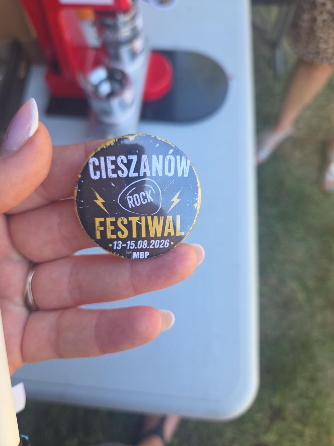 w dłoni trzymana plakietka ze wzorem Cieszanów Rock Festiwal