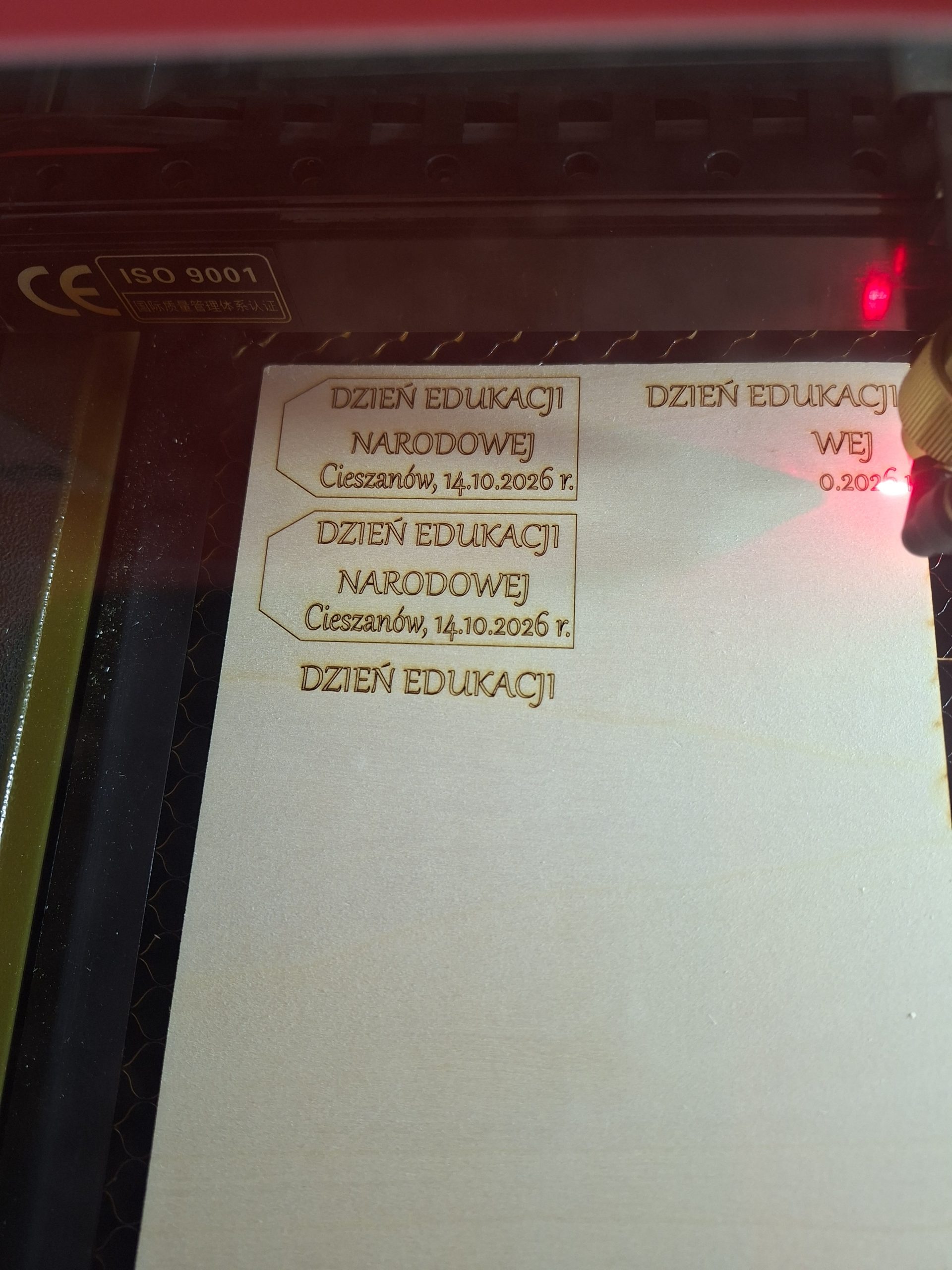 ploter laserowy wycina etykietkę z napisem Dzień Edukacji Narodowej Cieszanów