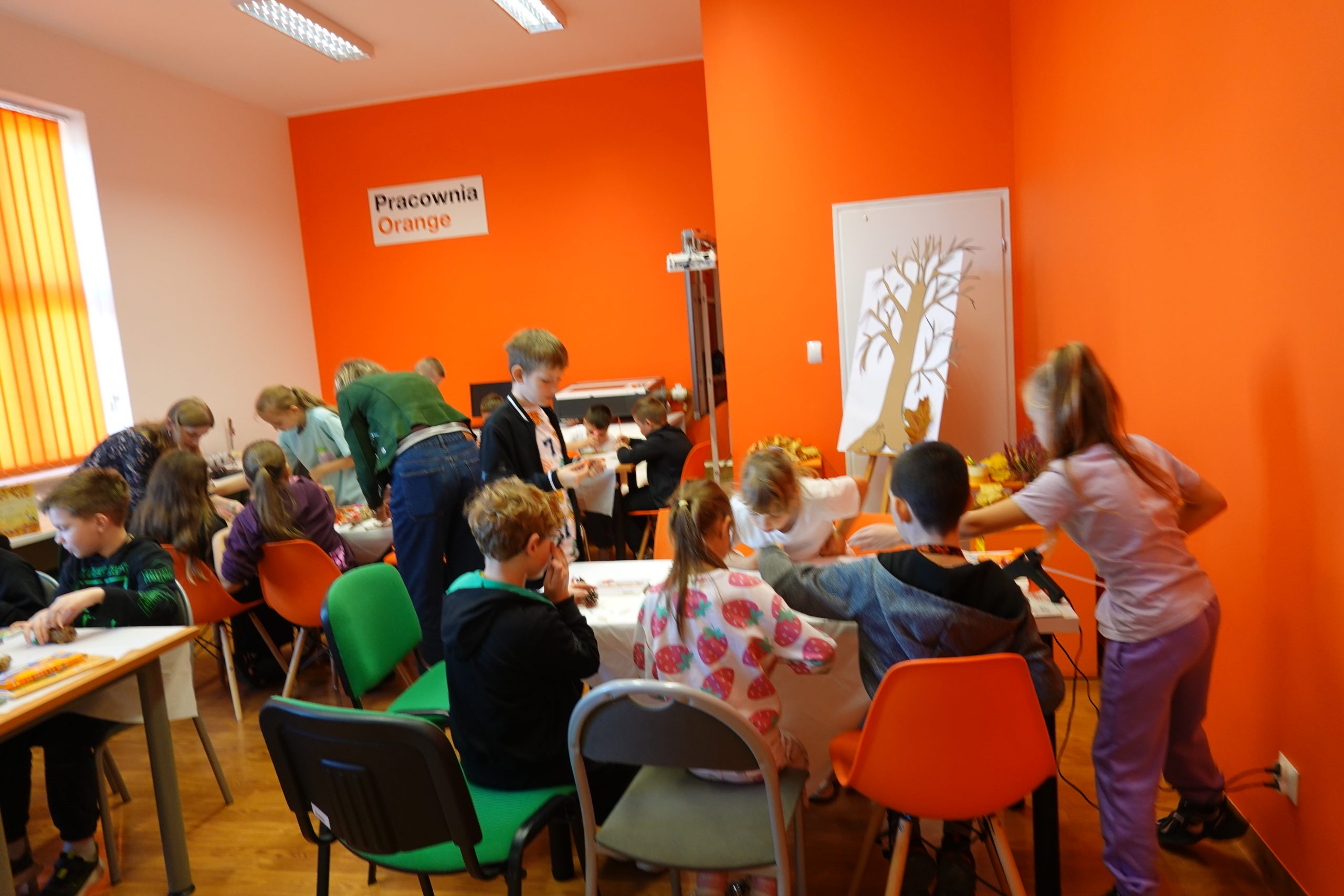 dzieci w pracowni Orange wykonujące jesienną wystawę