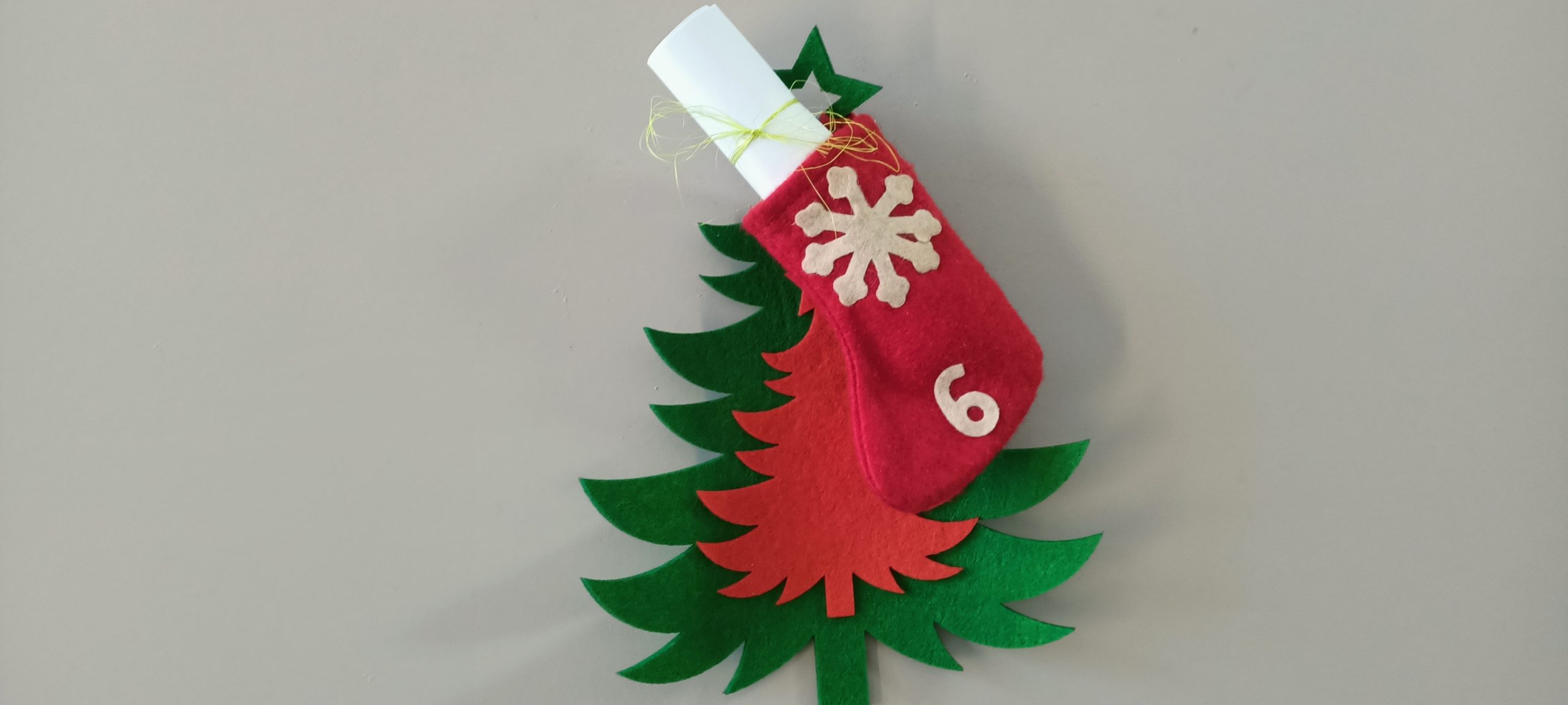 Czerwono-zielona choinka z filcu oraz świąteczny but na prezenty.