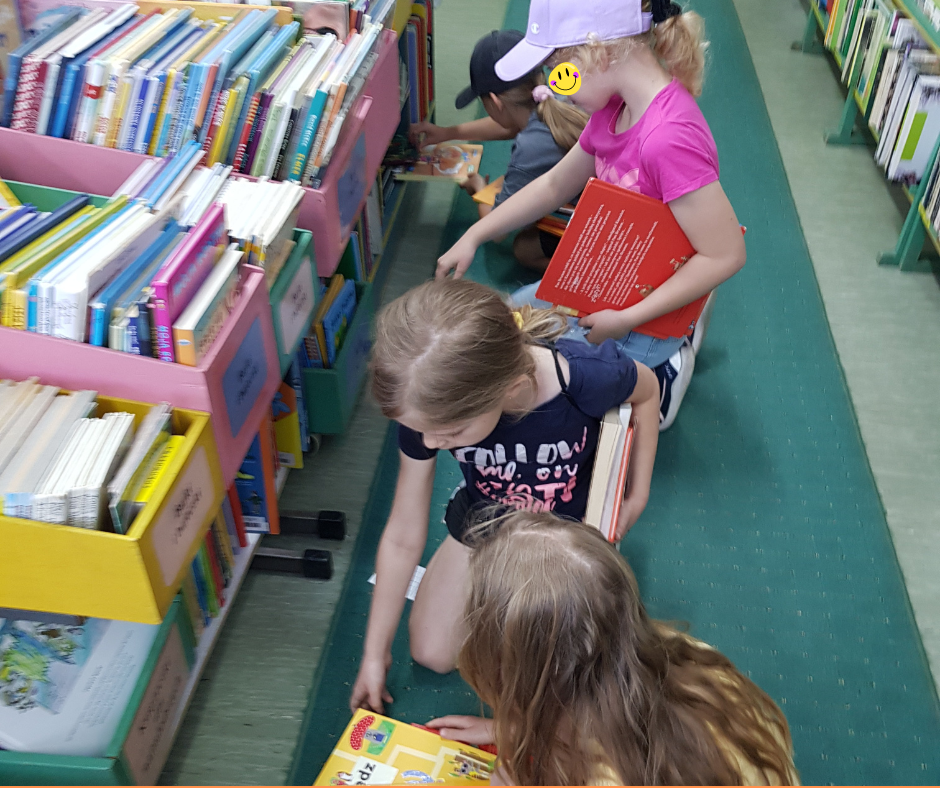 Dzieci między półkami z książkami.