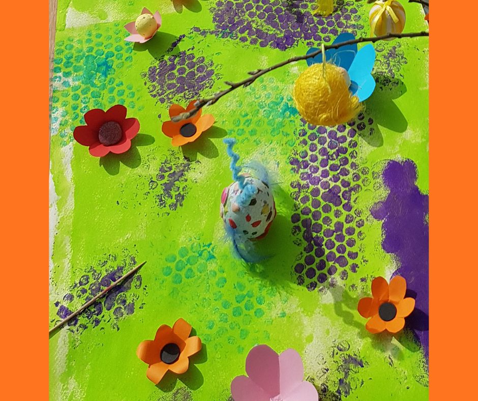Obraz stworzony przez dzieci przedstawiający fantazyjną kolorową łąkę z elementami 3D w postaci papierowych kwiatów
