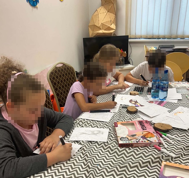 dzieci przy stole kolorujące obrazki manga