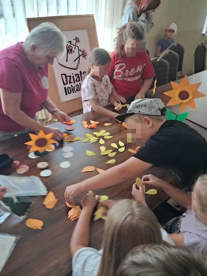 dzieci i panie sklejające kwiaty słonecznika
