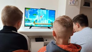 Trzej chłopcy podczas gry na PS4