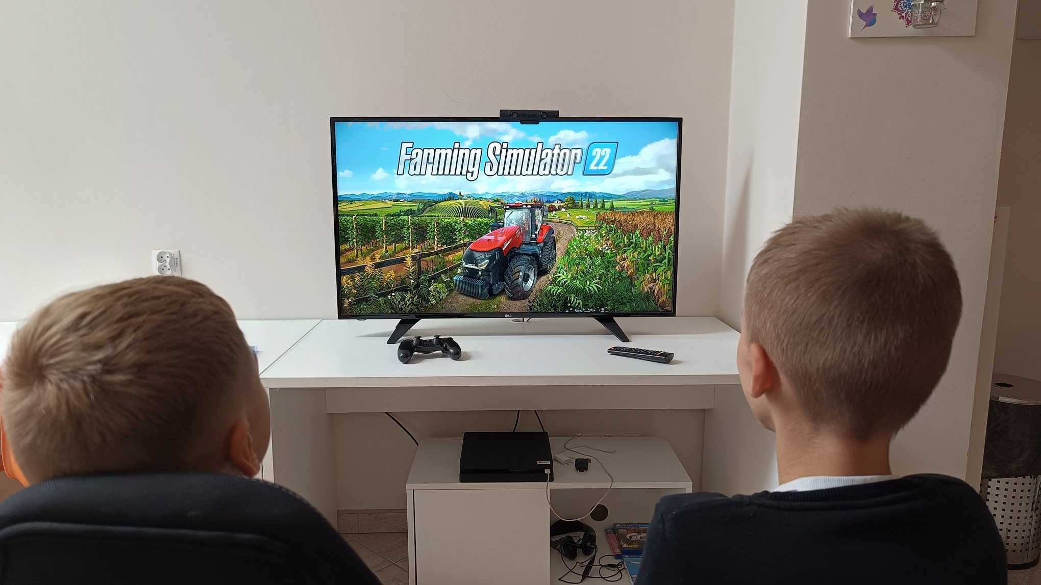 Dwaj chłopcy przy komputerze, na monitorze widoczna gra na PS4