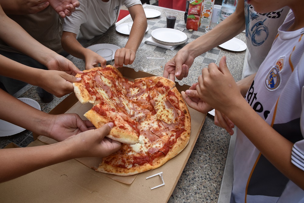 dzieci jedzą pizzę