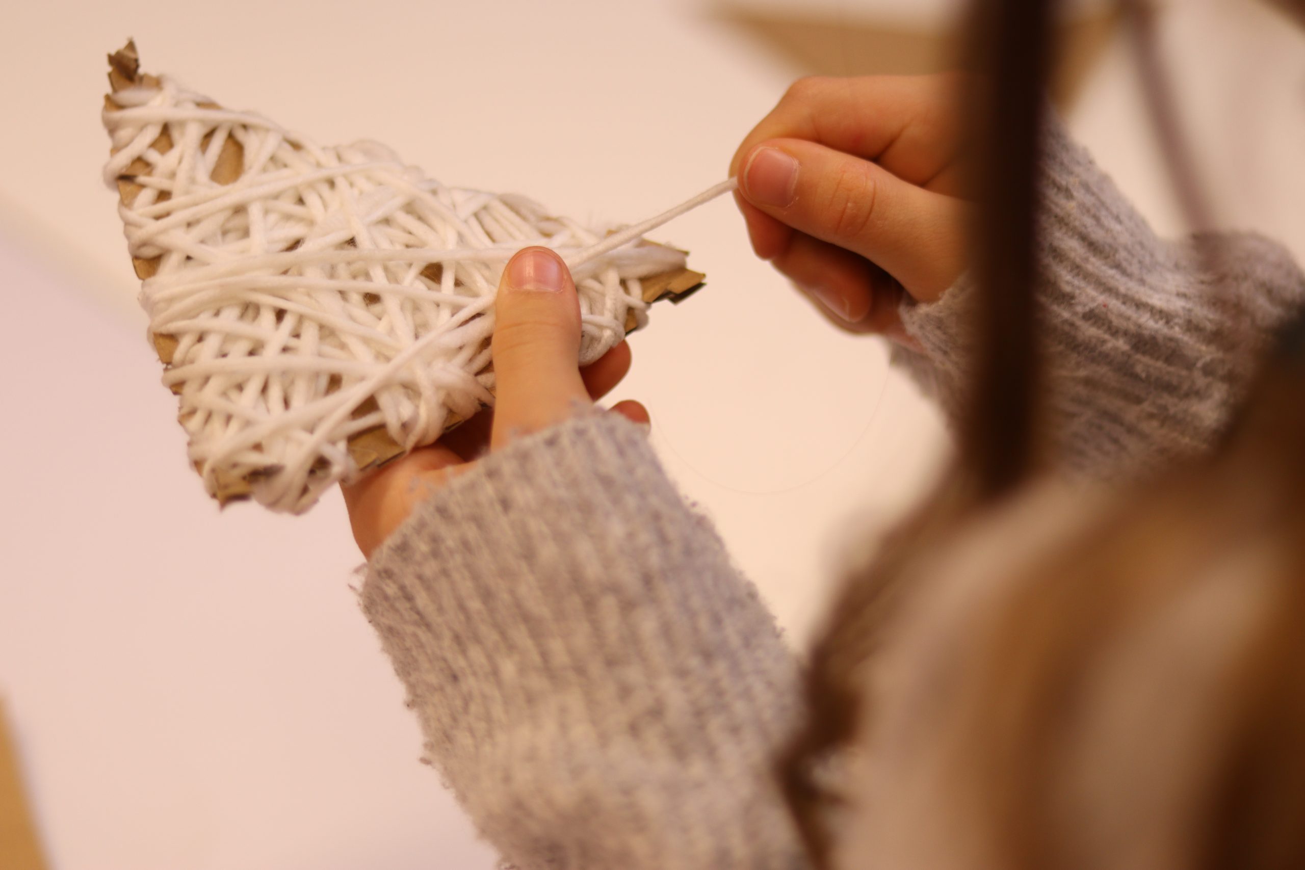 Wykonywanie zwierzątka przez dziecko - owijanie tekturki włóczką